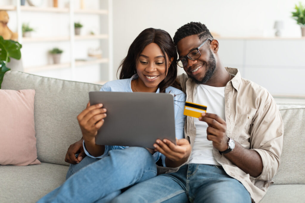 black-couple-using-pc-and-debit-credit-card-at-hom-2022-12-16-07-11-35-ut
