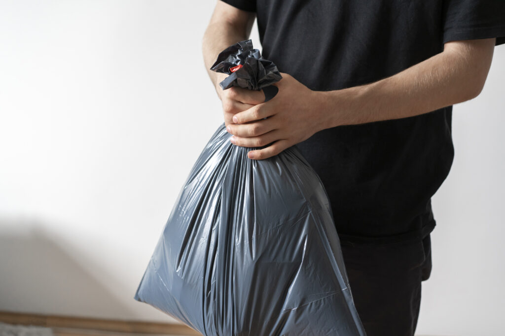 holding-plastic-garbage-bag-take-out-the-trash-2022-11-09-05-00-11-utc