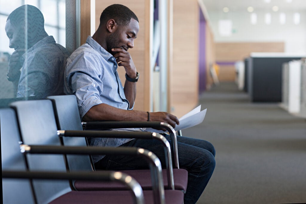 man-sitting-on-chair-reading-document-2022-03-07-23-56-34-utc