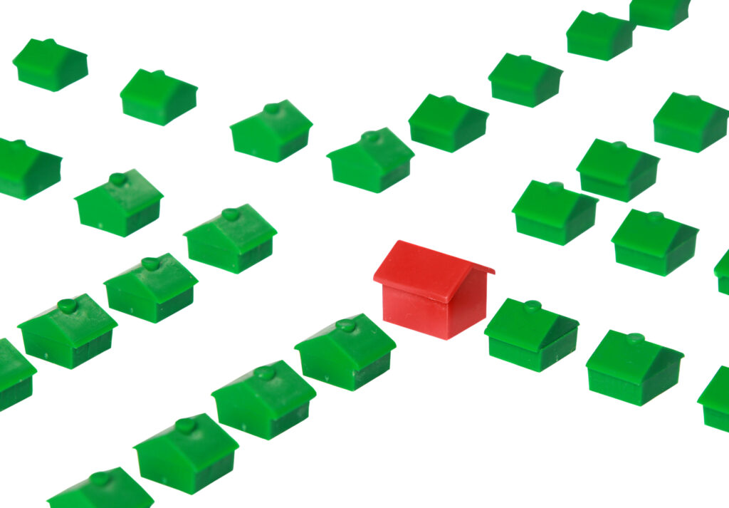 red-replica-house-standing-out-among-green-houses-2023-03-03-20-44-40-utc
