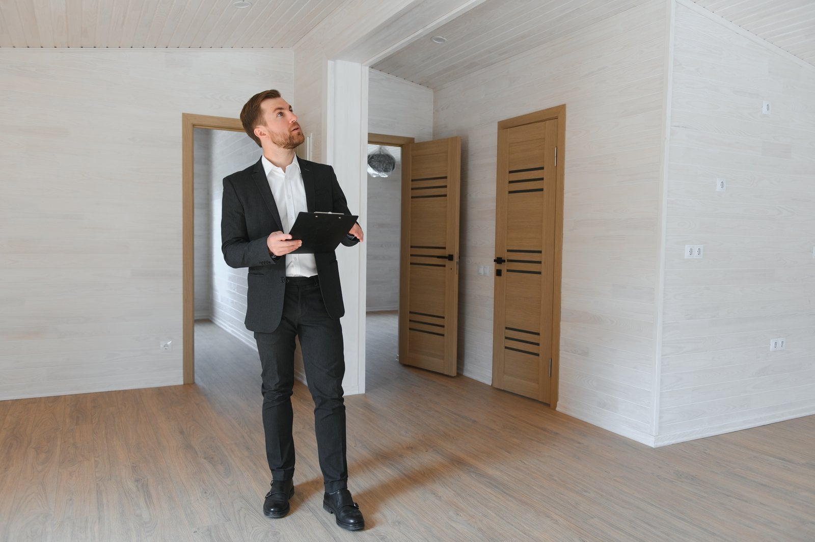 A property consultant inspecting an empty Bangkok condo unit with a clipboard, checking the finishes before purchase